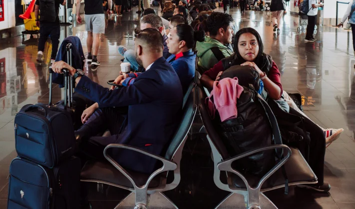 Passengers waiting at airport with luggage