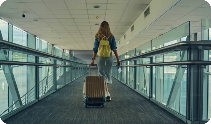 Person with luggage walking through airport corridor