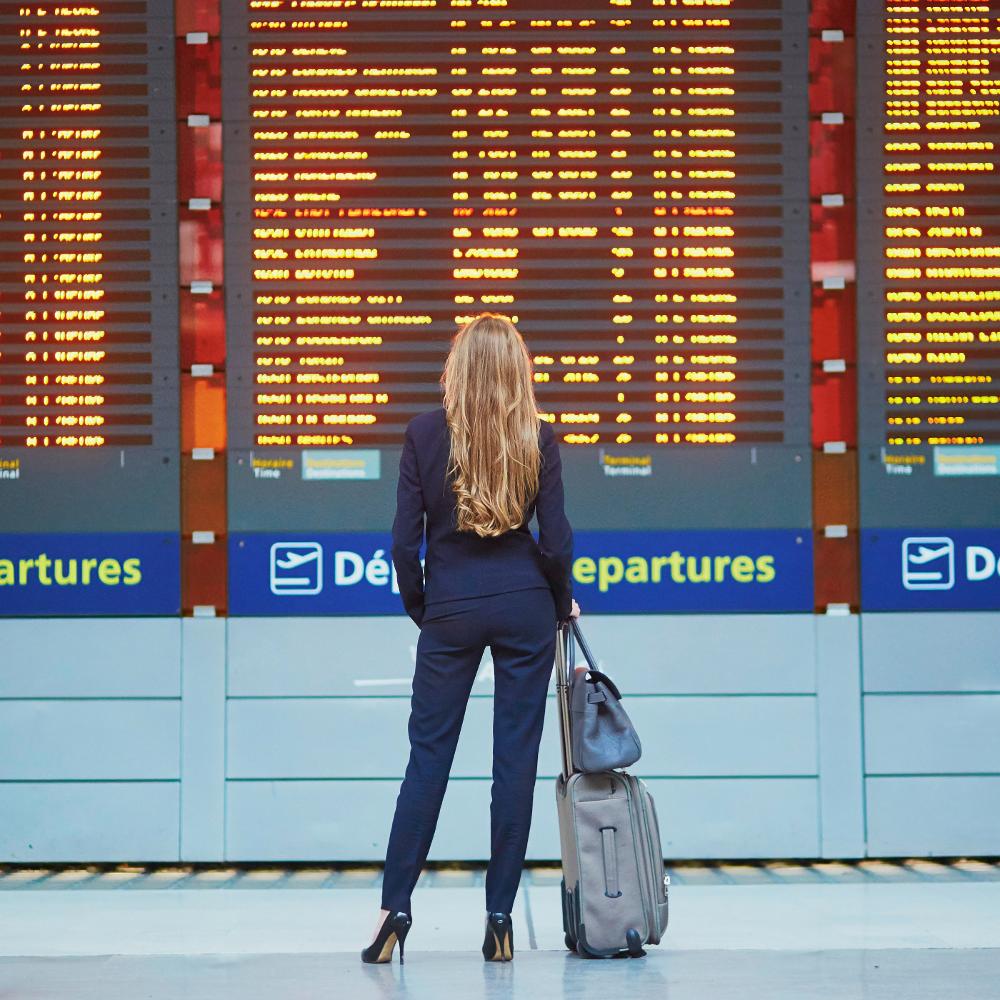 Woman standing in front of departures board